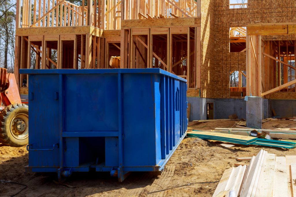 Old and used construction material in the new building frame of a new house under construction